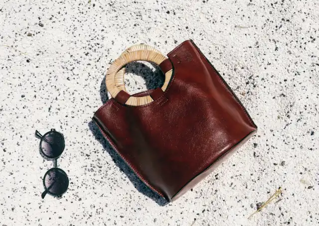 Oxblood leather handbag flat lay with sunglasses
