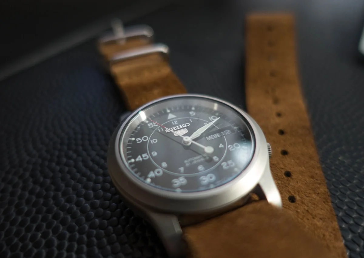 Field watch with brushed steel case and brown strap