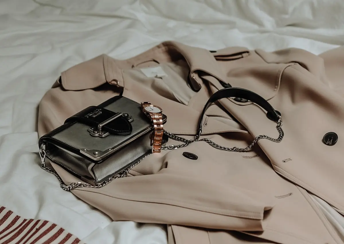 Sand trench coat flat lay with accessories